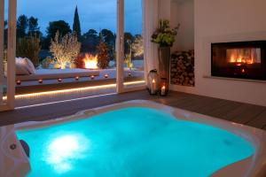 a hot tub in a room with a fireplace at Les Chambres Romantiques - JACUZZI Privatif, Domaine Aixois d'exception in Aix-en-Provence