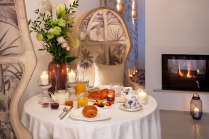 einen Tisch mit einem Teller Essen und Kerzen darauf in der Unterkunft Les Chambres Romantiques - JACUZZI Privatif, Domaine Aixois d'exception in Aix-en-Provence