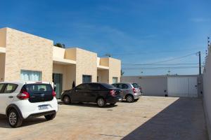 tres autos estacionados en un estacionamiento frente a un edificio en Vila Girassol, en Aracaju