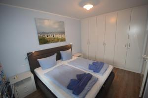 Un dormitorio con una cama con almohadas azules. en Likedeeler Whg. 7, en Boltenhagen