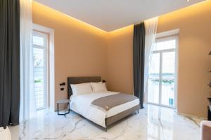 a bedroom with a bed and two windows at InSogno Suites in Naples