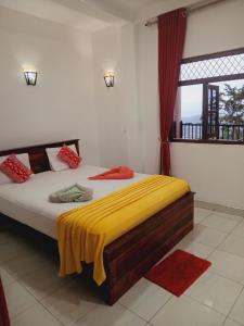 Kandy IVY Mountain View Resort في كاندي: غرفة نوم عليها سرير مع بطانية صفراء