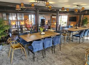 a dining room with two tables and blue chairs at Pensjonat Retro in Łomża