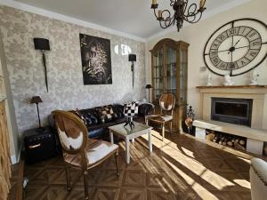 a living room with a couch and a clock on the wall at Villa Liguardi in Proaño