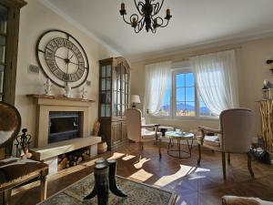 a living room with a large clock and a fireplace at Villa Liguardi in Proaño