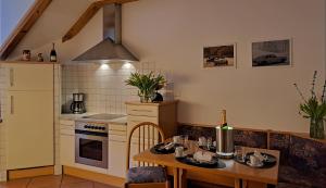una cucina con tavolo, piano cottura e lavandino di Penthouse&Wellness L'Abete a Gargazzone
