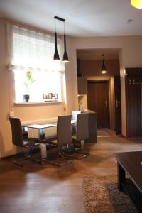 een eetkamer met een tafel en stoelen en een raam bij Apartament Integro in Szczecin