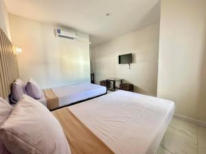 a hotel room with two beds and a tv at 24 Sleep Resort Khlong Luang Hospital in Khlong Luang
