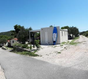 a surfboard is sitting on the side of a building at Two Roses Mobile Home in Jezera