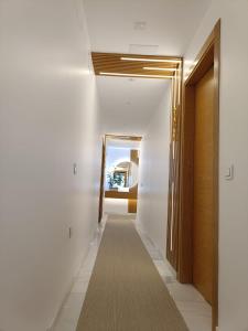 a hallway with white walls and a carpet on the floor at APARTAMENTOS SAN NICOLAS in Adra