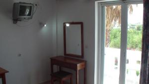 a mirror sitting on a wall next to a tv at Creta Vassakis Studios in Kefalos