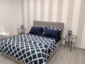 a bedroom with a bed with a blue and white comforter at Villa sullo stretto in SantʼAgata