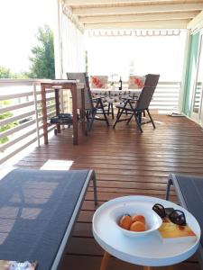 a plate of fruit on a table on a deck at Two Roses Mobile Home in Jezera