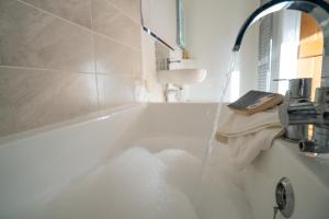 a bathroom with a bath tub with water coming out at The Granary at Red House Farm in Stradbroke