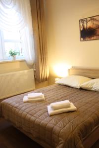 een slaapkamer met een bed met twee handdoeken erop bij Apartament Integro in Szczecin