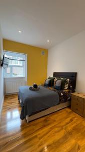 1 dormitorio con 1 cama grande y suelo de madera en Kensington Guest Rooms 98, en Londres