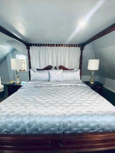 a large bed in a bedroom with two lamps at 1000 Islands Bed and Breakfast-The Bulloch House in Gananoque