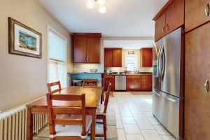 a kitchen with a wooden table and a refrigerator at Gloucester Coastal Gem in Gloucester