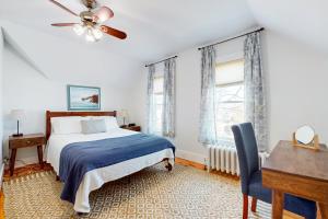 a bedroom with a bed and a desk and a ceiling fan at Gloucester Coastal Gem in Gloucester