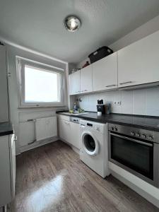 a kitchen with a washing machine and a window at Room in Apartment next to ST Hbf in Stuttgart