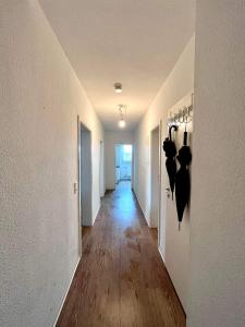 a hallway with white walls and a wooden floor at Room in Apartment next to ST Hbf in Stuttgart