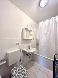 a white bathroom with a sink and a shower at Room in Apartment next to ST Hbf in Stuttgart