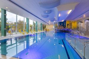 a large indoor swimming pool with blue water at IFA Graal-Müritz Hotel & Spa in Graal-Müritz