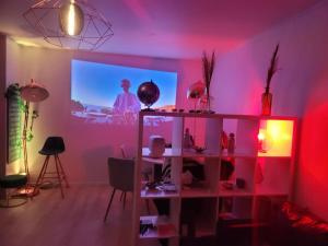 un salon avec une chambre rose et une télévision dans l'établissement Elégant appartement familial- Paris à porte - au pied de la ligne 14, à Clichy