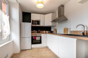 een keuken met witte kasten en een koelkast bij Le Plaidoyer in Limoges