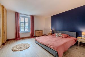 een slaapkamer met een groot bed en een blauwe muur bij Le Plaidoyer in Limoges +8 foto's