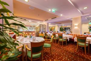 een eetkamer met witte tafels en stoelen bij IFA Graal-Müritz Hotel & Spa in Graal-Müritz