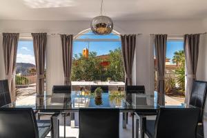 uma sala de jantar com uma mesa de vidro e cadeiras em Villa del Duque Chayofa em Chayofa