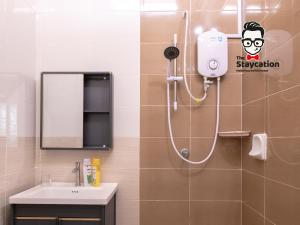 a bathroom with a shower with a sink and a mirror at Staycation Homestay 40 Tmn Sucihandal Nr Kch City Mall in Kuching