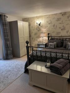 ein Schlafzimmer mit einem Bett und einem Tisch mit einer Lampe in der Unterkunft Luxury Farm Country Retreat in Chippenham