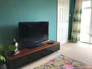 a living room with a flat screen tv on a entertainment center at LetAway - Tom's Cabin, Staithes in Staithes