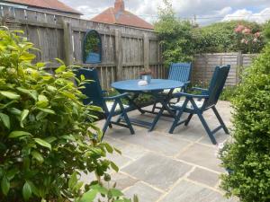 a patio with a blue table and two chairs at LetAway - Tom's Cabin, Staithes in Staithes