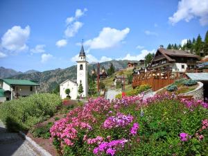 a small town with a clock tower and flowers at Chalet in pietra in Antey-Saint-André