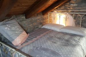 una cama de metal con almohadas encima en Chalet in pietra, en Antey-Saint-André