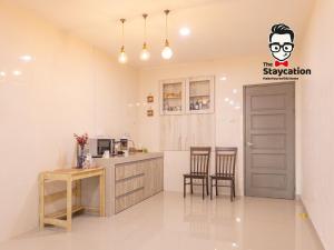 a kitchen with a table and chairs and a door at Staycation Homestay 40 Tmn Sucihandal Nr Kch City Mall in Kuching