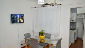 Un comedor con una mesa de cristal y sillas. en Tu departamento en Buenos Aires!, en Buenos Aires