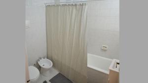 Un baño con inodoro, lavabo y ducha. en Tu departamento en Buenos Aires!, en Buenos Aires 6 fotos más