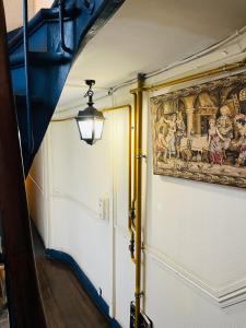 einen Flur mit einer Tür und einem Gemälde an der Wand in der Unterkunft Dream Dwell Paris- 650m to Notre Dame Apartment near Odéon in Paris