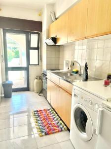 a kitchen with a washing machine and a colorful rug at Amazing Studio Flat Albufeira in Albufeira