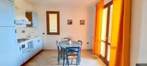 eine Küche mit einem Tisch und Stühlen im Zimmer in der Unterkunft I fiori di Alberese in Alberese
