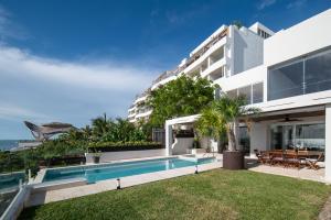 Una vista exterior de un edificio con piscina. en Villa Chan Kah, en Isla Mujeres