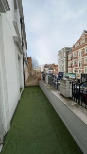 a balcony with green grass on the side of a building at Kensington Guest Rooms 98 in London