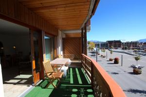 - une terrasse couverte avec 2 chaises et une table dans un bâtiment dans l'établissement Apartment Corfou, à Crans-Montana