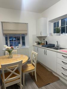 a kitchen with a wooden table and a table and chairs at Cosy Cottage in Crawley