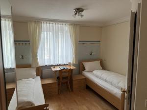 a small room with two beds and a table at Wallfahrtswirt in Wemding