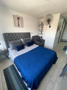 1 dormitorio con 1 cama grande con manta azul en Departamento en Santiago centro cerca de movistar arena, Caupolican, en Santiago